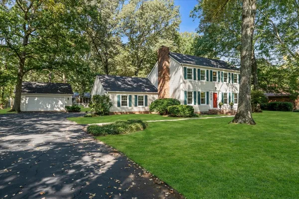 a front view of a house with a yard and trees