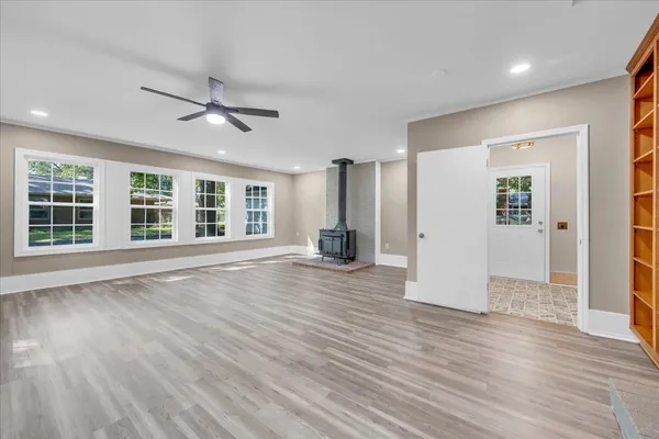 a view of empty room with wooden floor and window