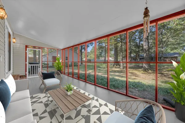 a view of a living room filled with furniture and floor to ceiling windows