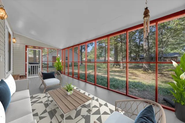 a view of a living room filled with furniture and floor to ceiling windows