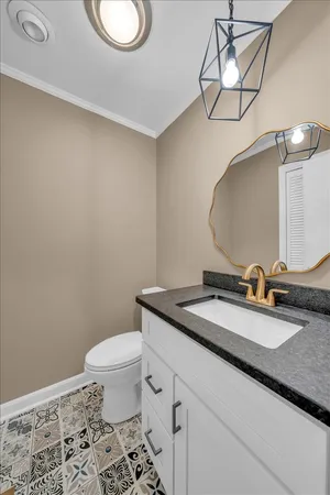 a bathroom with a granite countertop toilet sink and mirror
