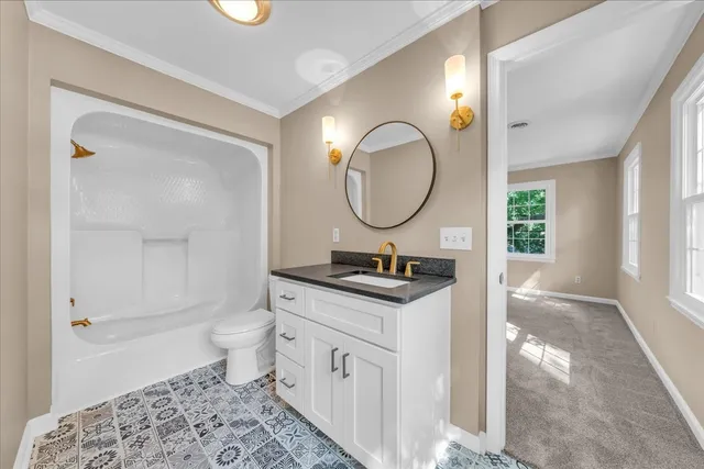 a bathroom with a granite countertop sink toilet and a mirror