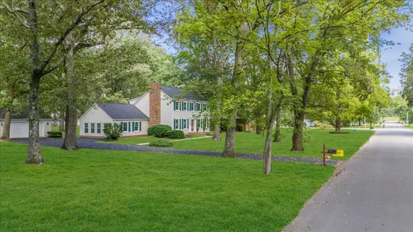 a front view of a house with a yard and trees