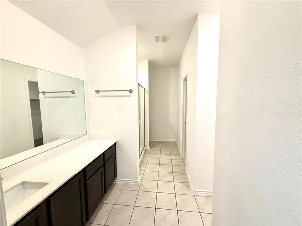 a hallway with a sink and a mirror