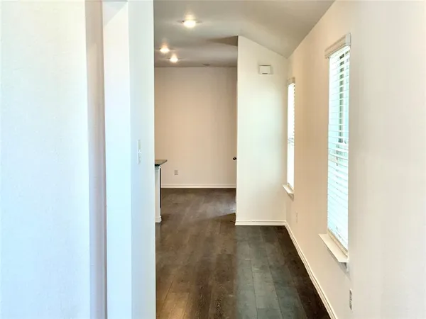 a view of a hallway with wooden floor