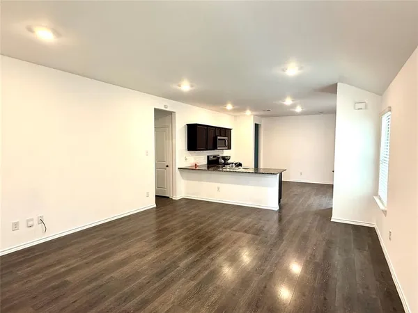 a view of kitchen with microwave and refrigerator