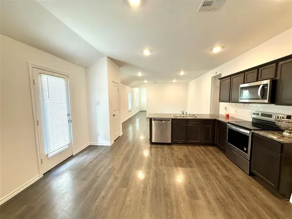a large kitchen with a sink and stainless steel appliances