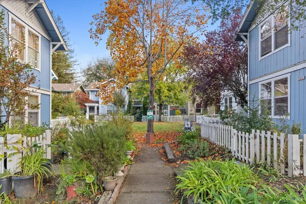a view of a brick house with a large trees and yard next to a road