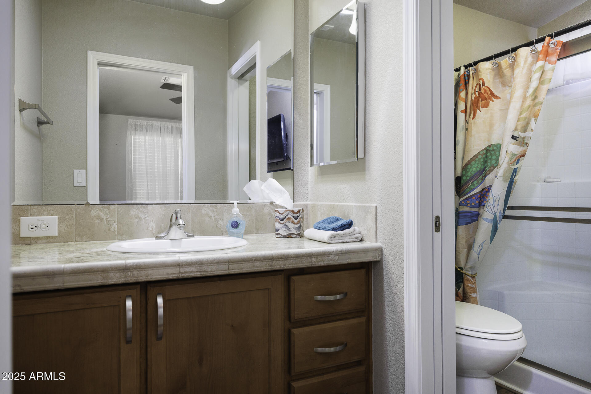 1110 North Henness Road, Unit 1351 Casa Grande, AZ 85122 - Photo 18 of 62 a bathroom with a granite countertop sink a toilet and a mirror