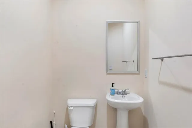 a bathroom with a sink mirror and toilet