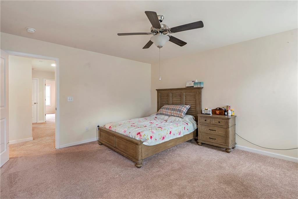4265 Almanor Circle Norcross, GA 30071 - Photo 15 of 34 a bedroom with a bed and a chandelier fan