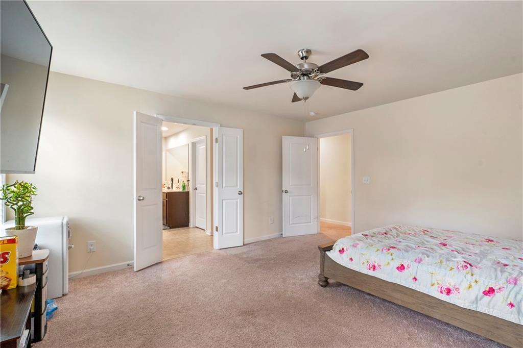 4265 Almanor Circle Norcross, GA 30071 - Photo 16 of 34 a bedroom with a bed and a chandelier