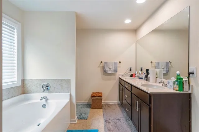 a bathroom with a tub sink and mirror