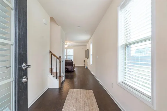 a view of a hallway with wooden floor and windows