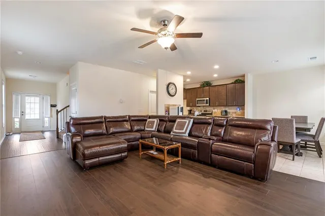 a living room with furniture kitchen view and a chandelier
