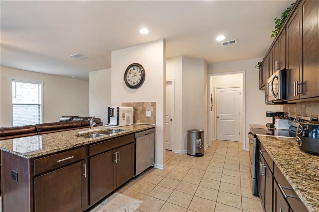 4265 Almanor Circle Norcross, GA 30071 - Photo 10 of 34 a kitchen with a sink and a stove top oven with wooden floor