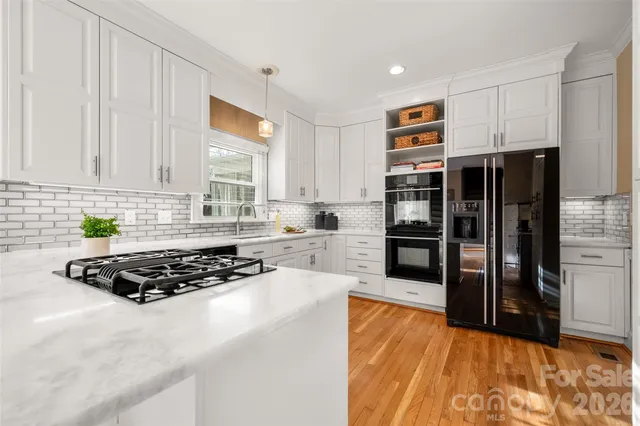 a kitchen with stainless steel appliances granite countertop a refrigerator and a stove top oven
