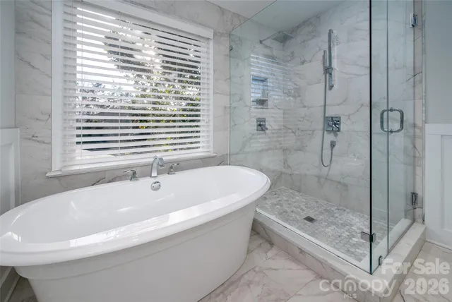 a white bath tub sitting next to a shower