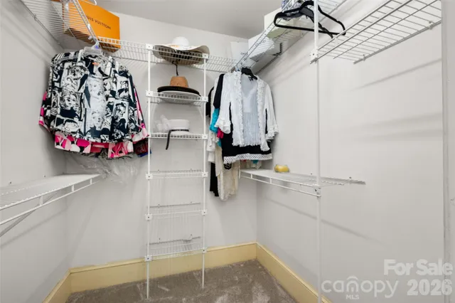 a view of walk in closet with clothes and shoes