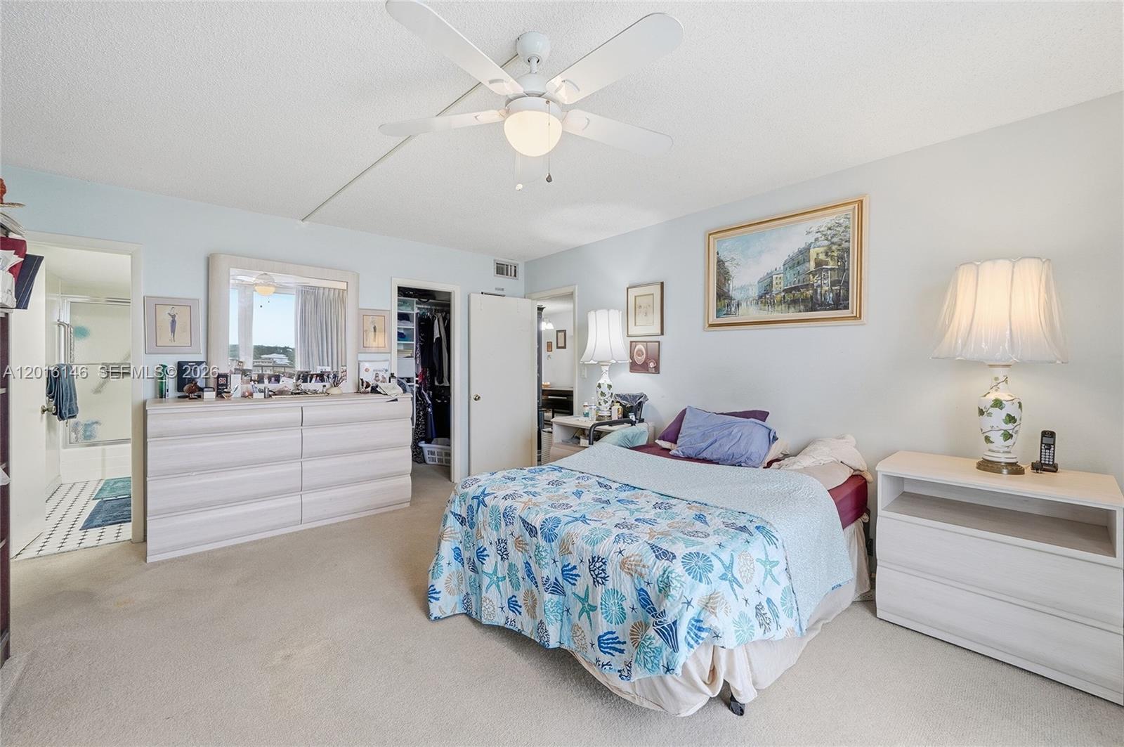 521 North Riverside Drive, Unit 606 Pompano Beach, FL 33062 - Photo 18 of 50 a bedroom with a bed and a chandelier