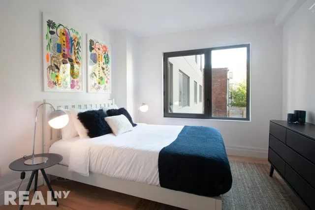 a kitchen with stainless steel appliances a stove a sink dishwasher a refrigerator and white cabinets with wooden floor