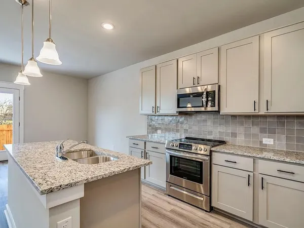 a kitchen with a sink stove and cabinets