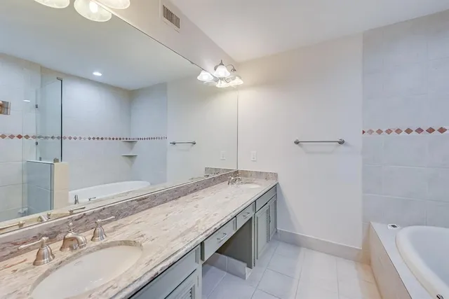 a bathroom with a granite countertop sink a toilet a mirror and shower