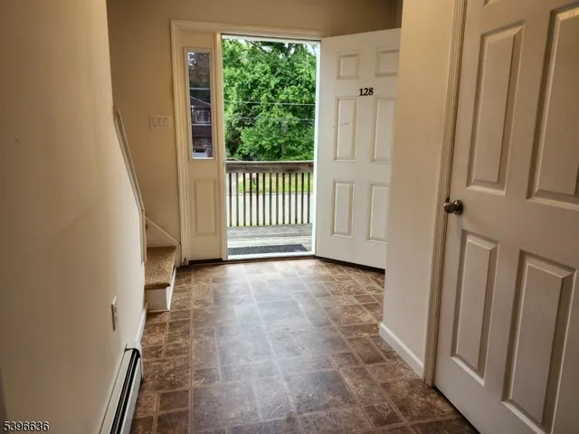 a view of a hallway with wooden floor and stairs