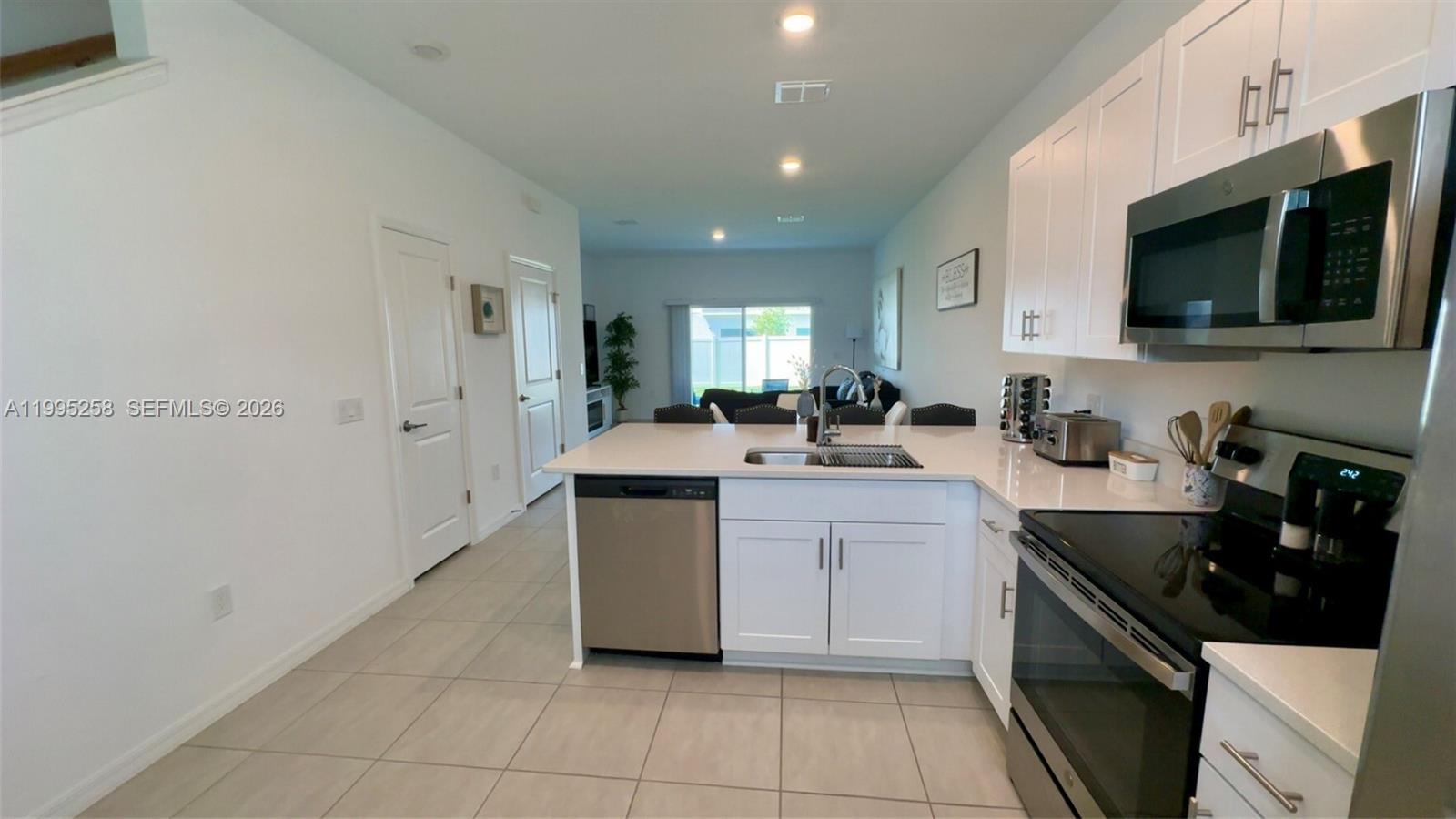 3381 Composition Street Kissimmee, FL 34758 - Photo 3 of 16 a kitchen with stainless steel appliances a sink stove and microwave