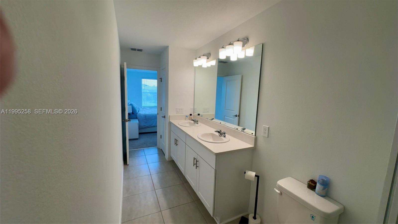 3381 Composition Street Kissimmee, FL 34758 - Photo 9 of 16 a bathroom with a double vanity sink and mirror