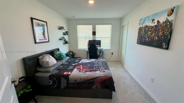 a bedroom with bed and a painting on the wall