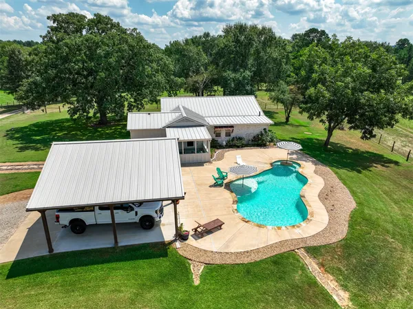an aerial view of a house with a yard and lake view