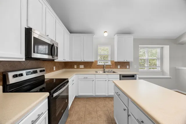 a kitchen with a sink stove top oven and refrigerator