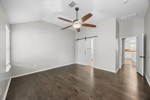 a view of an empty room with a ceiling fan and a window