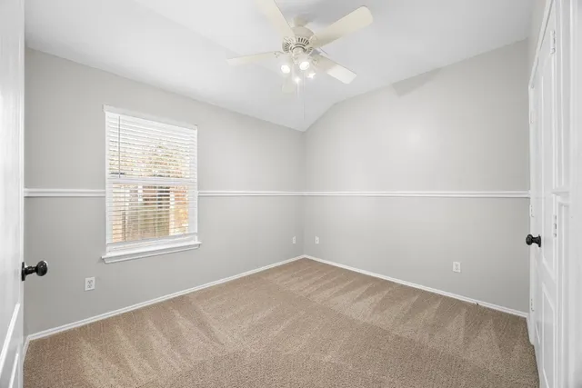 an empty room with a window and a ceiling fan