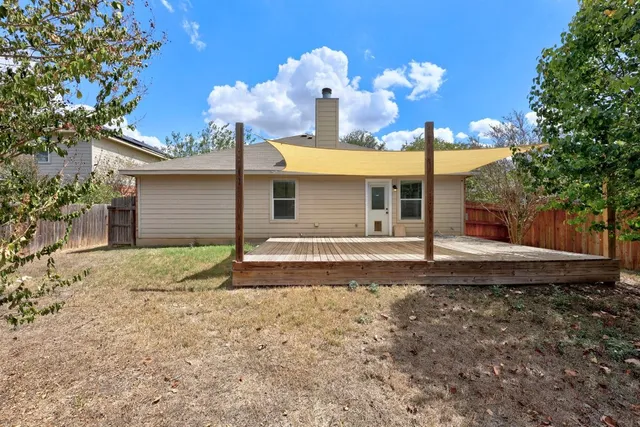 a view of a house with a yard and large tree