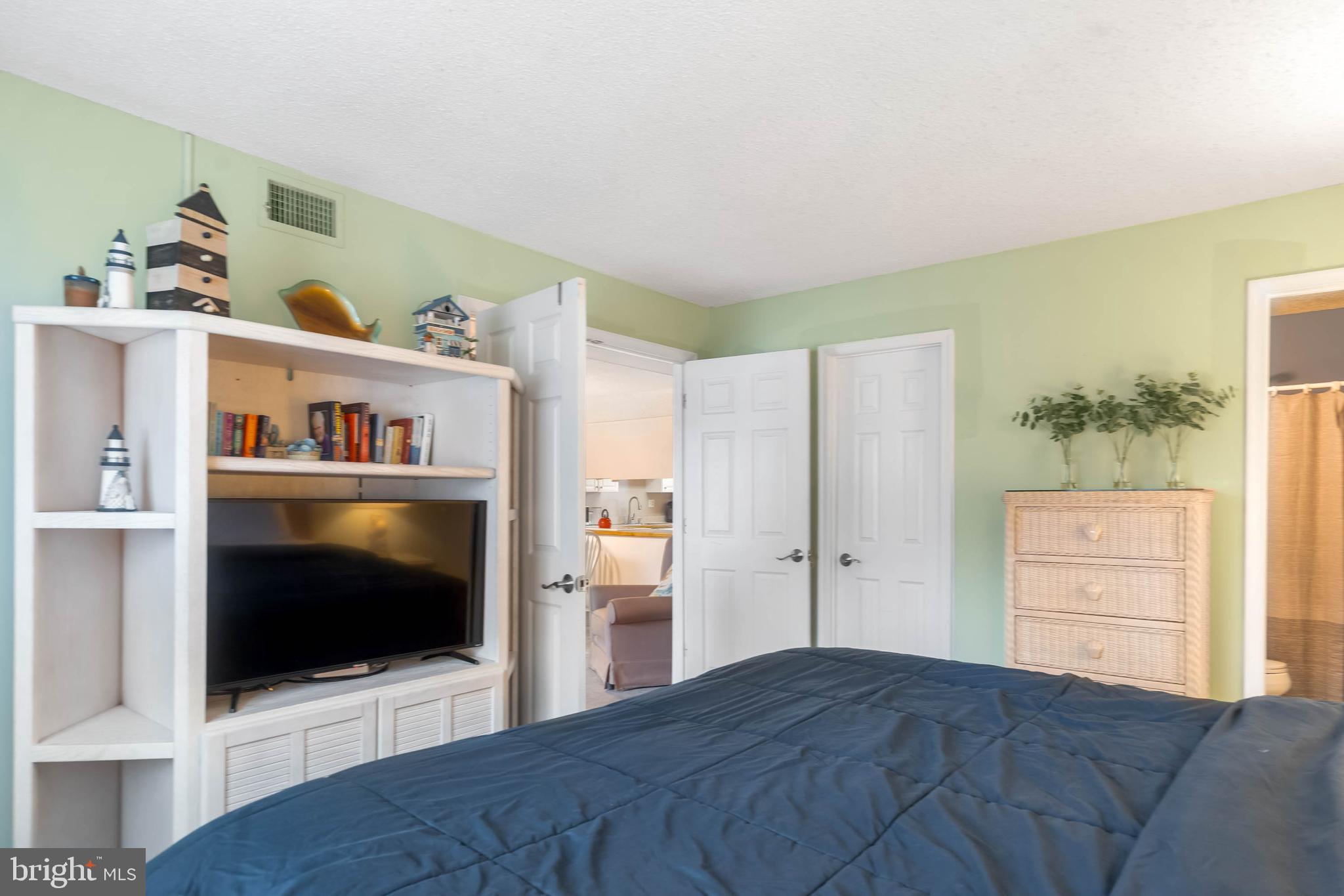 9203 Rusty Anchor Road, Unit A3 Ocean City, MD 21842 - Photo 15 of 40 a bedroom with a bed and a flat screen tv