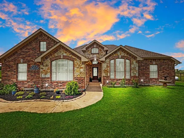 a front view of a house with a garden and plants