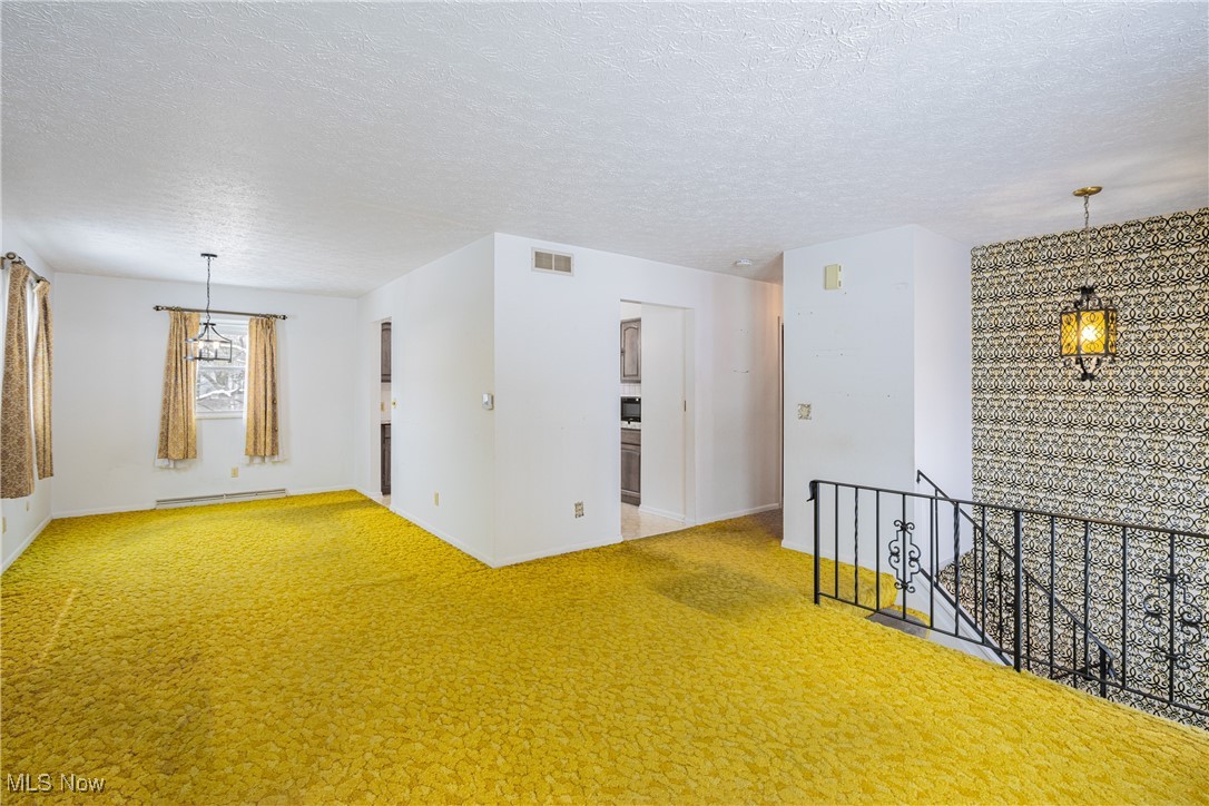 5905 Renninger Road New Franklin, OH 44319 - Photo 6 of 31 Carpeted spare room featuring baseboard heating and a textured ceiling