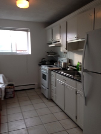 38 Westgate Road, Unit 5 Boston, MA 02467 - Photo 3 of 10 a kitchen with stainless steel appliances a sink stove and refrigerator