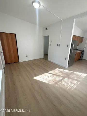 a view of a kitchen with a sink refrigerator and a window
