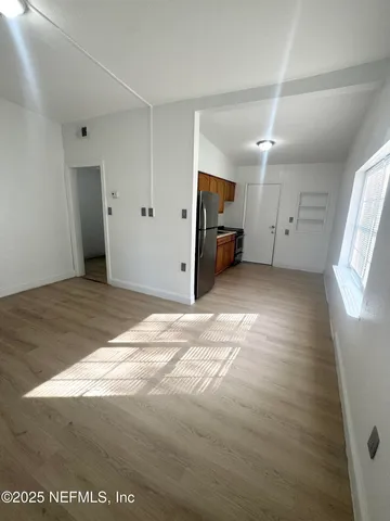 a kitchen with stainless steel appliances a refrigerator and a wooden floor