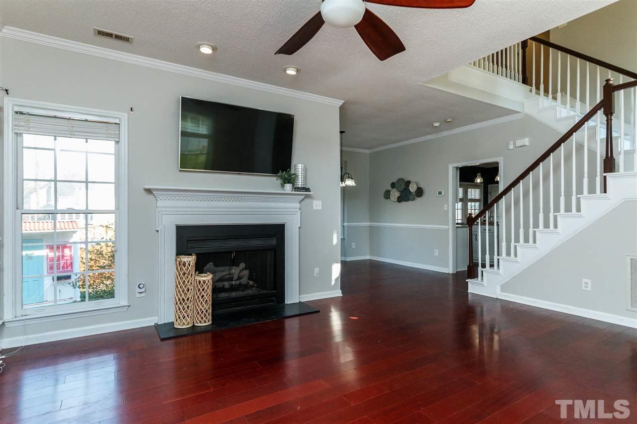 11205 North Radner Way Raleigh, NC 27613 - Photo 4 of 22 a living room with wooden floor and a fireplace