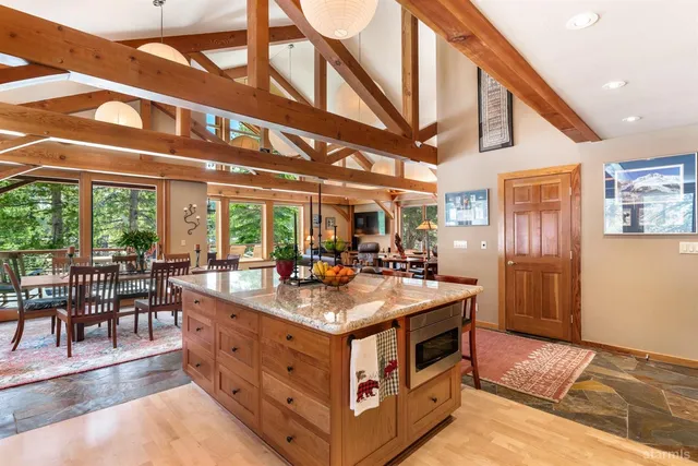 a dining hall with stainless steel appliances granite countertop a stove and cabinets