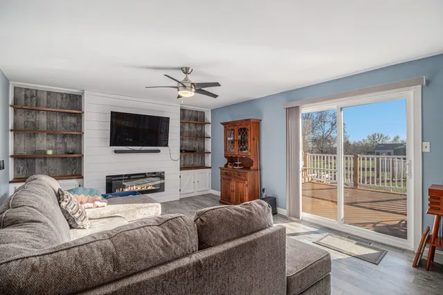 a living room with furniture a flat screen tv and a large window