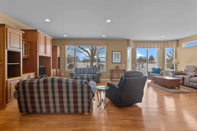 a living room with furniture floor to ceiling window and wooden floor