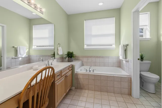 a spacious bathroom with a tub sink and mirror