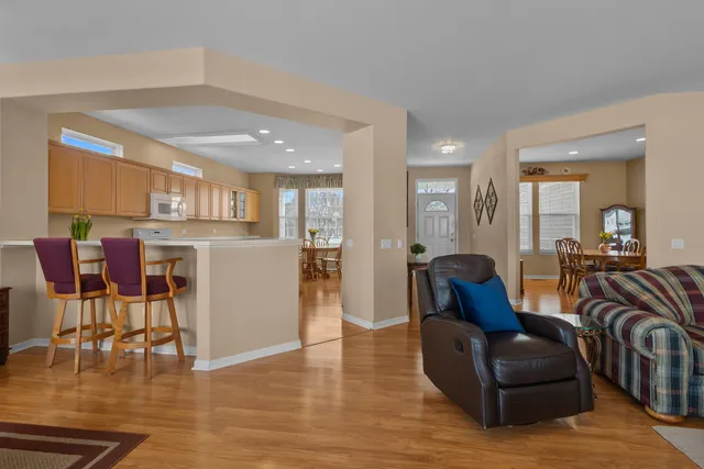 a living room with furniture and kitchen view with wooden floor