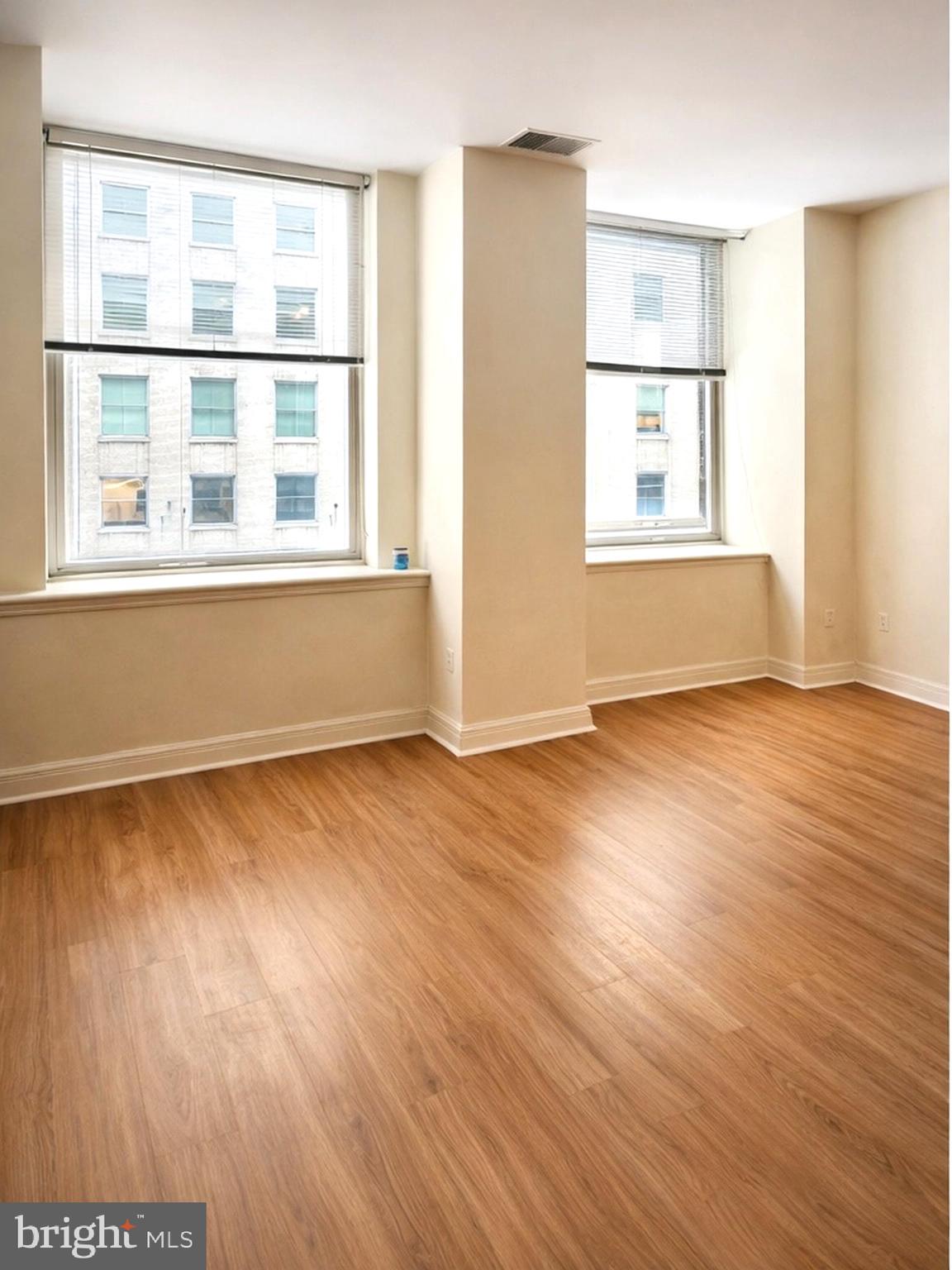 1600 Arch Street, Unit 612 Philadelphia, PA 19103 - Photo 2 of 11 a view of an empty room with wooden floor and a window