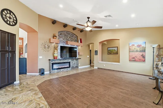 a view of a livingroom with furniture a ceiling fan and floor to ceiling window